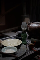 Vintage oil lamp on a table with rustic pottery