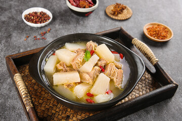 Traditional Asian beef brisket stew with white radish chunks in clear broth on bamboo serving tray