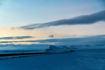 A beautiful snowy winter landscape from southern Iceland, basking in the beautulf soft pink light of a low hanging sun. Winterdays in Iceland are marked by a perpetual golden hour.