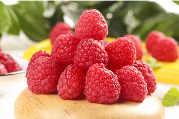 Fresh Red Raspberries on Wooden Board with Mixed Fruits Background