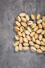 Salted Roasted Pistachios Scattered on Gray Textured Background - Healthy Snack Food Photography