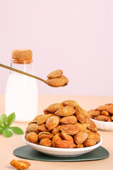 Raw Almonds in Bowl with Spoon on Pink Background - Healthy Nuts Snack Food Ingredient