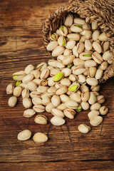 Fresh Roasted Pistachios Spilling from Woven Basket on Rustic Wood Table - Healthy Snack Food Photography
