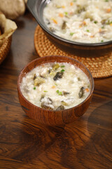 Traditional Chinese Rice Porridge with Eggs and Pork - Healthy Breakfast Congee in Wooden Bowl