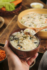 Traditional Chinese Rice Porridge with Lean Pork and Egg - Healthy Breakfast Congee in Wooden Bowl