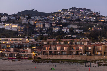 Twilight view of housing and buildings along the hilly coast of Pismo Beach, California, USA.