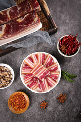 Traditional Woodsmoked Bacon and Pork Charcuterie with Spices on Dark Rustic Background