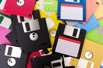 Computer retro vintage collectibles. Background Pile of black and other colorful colors obsolete Diskette or Floppy Disks 3.5 inches with empty label sticker.