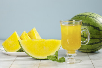 Fototapeta premium Fresh Yellow Watermelon Slices and Juice with Mint on White Wood Background
