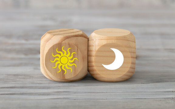 Mourning and night concept. Abstract geometric wooden dice.  AM, PM  icon. Sun and moon.