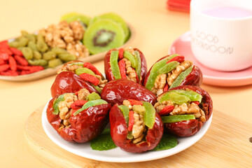Xinjiang Dried Dates Stuffed with Walnuts and Kiwi Garnish on White Plate - Healthy Middle Eastern Snack