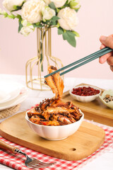 Spicy Cooked Squid Being Picked Up with Chopsticks - Asian Seafood Cuisine