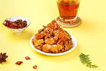 Spicy Glazed Squid Dish with Tea and Spices on Yellow Background - Asian Seafood Cuisine