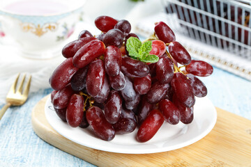 Fresh Red Grapes with Mint Garnish on White Plate - Healthy Fruit Snack