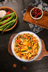Asian Stir Fry Tofu with Dried Vegetables and Aromatic Spices on Wooden Table