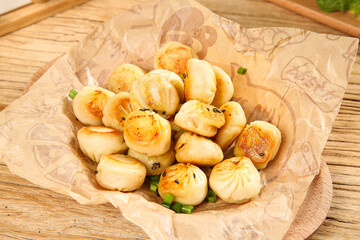 Golden Shengjian Buns Chinese Pan-Fried Dumplings on Wood Background Breakfast Food