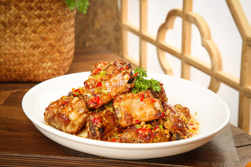 Delicious Fried Spare Ribs with Garlic and Peppers on White Plate - Asian Style Barbecue Dish