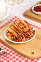 Spicy Cooked Squid Tentacles Served on Wooden Board with Red Sauce
