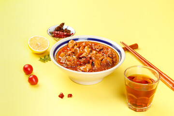 Spicy Marinated Calamari Squid in Tomato Sauce with Chopsticks and Tea on Yellow Background