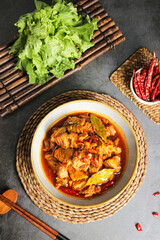 Spicy Beef Brisket Stew with Fresh Vegetables and Red Chilies on Bamboo Placemats