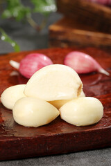 Fresh Peeled Garlic Cloves and Purple Shallots on Wooden Cutting Board Kitchen Ingredients