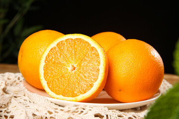 Fresh Navel Oranges with Cut Half Showing Juicy Segments on White Plate - Summer Citrus Fruit