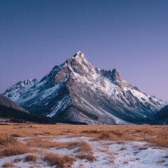 Fototapeta premium Majestic snow-capped mountain peak rises above a field of golden grass under a vibrant purple-pink sky