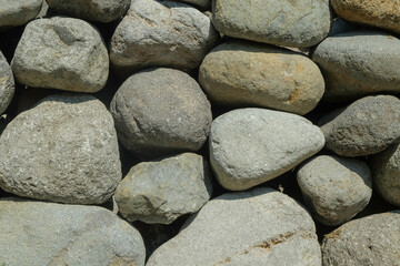 Background pattern and texture of stack of grey river rocks. For graphic design, banner background and 3d rendering