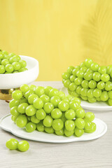 Fresh Green Grapes on White Plates with Golden Sunshine Background