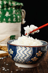 Steamed white rice in traditional ceramic bowl with chopsticks - Asian staple food nutrition concept