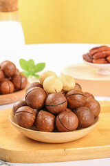 Macadamia Nuts in Wooden Bowl with Creamy Butter on Kitchen Cutting Board