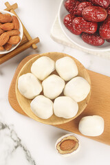 Handmade Cheese Rounds with Red Dates and Almonds on Marble Surface
