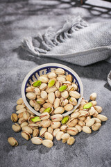 Fresh Pistachios in Bowl Spilling on Rustic Surface - Healthy Nuts and Dried Fruit Snack