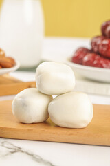 Fresh Mozzarella Cheese Balls on Wooden Board with Dates and Milk for Healthy Mediterranean Cooking