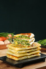 Handmade Breakfast Pastries with Egg Vermicelli and Leek Filling Stacked on Wooden Board