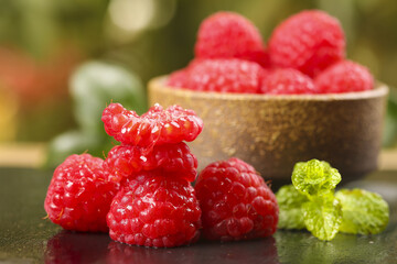 Fresh Red Raspberries with Water Drops and Mint Leaves in Wooden Bowl