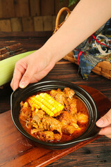 Korean Pork Rib Soup with Corn in Black Bowl on Wooden Table - Traditional Asian Comfort Food