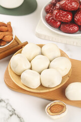 Handmade White Steamed Buns with Date Filling and Traditional Ingredients on Wooden Serving Plate