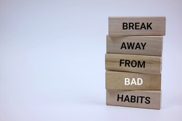Motivational wooden blocks forming the phrase 'Break Away From Bad Habits', emphasizing improvement and transformation