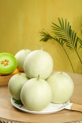 Fresh Jade Green Melons on Wooden Table with Palm Leaves - Healthy Organic Fruit Display