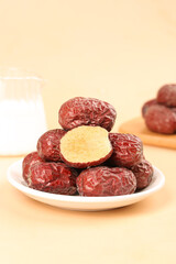 Dried Ruoqiang Jujube Dates from Xinjiang China on White Plate with Cut Open Fruit Showing Golden Interior