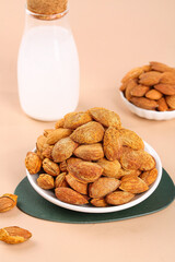 Raw almonds in shell with almond milk bottle - healthy nuts and natural snacks arrangement