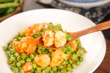 Sautéed Green Peas with Shrimp Dish on White Plate with Wooden Spoon