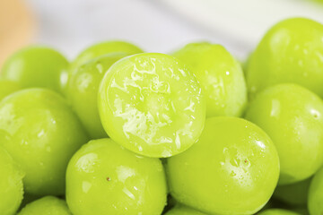 Fresh Green Seedless Grapes with Cut Half Showing Juicy Interior in Sunny Light
