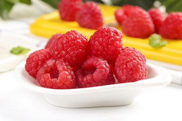 Fresh Red Raspberries in White Bowl with Mixed Fruit Background
