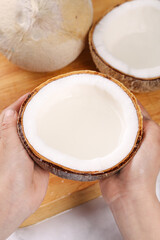 Fresh Coconut Milk in Natural Shell - Traditional Thai Tropical Drink with Whole Coconuts on Wooden Background