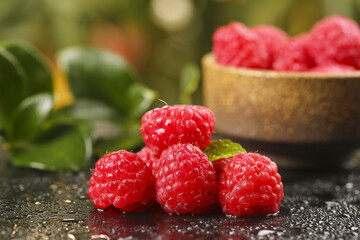 Fresh Red Raspberries with Wooden Bowl and Green Leaves on Dark Surface