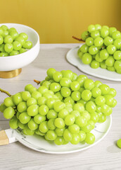 Fresh Green Grapes on White Plates with Natural Light and Warm Golden Background