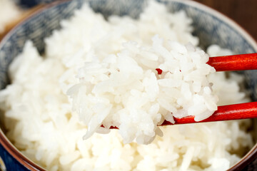 Cooked White Rice with Red Chopsticks in Traditional Bowl - Asian Food Staple Studio Shot