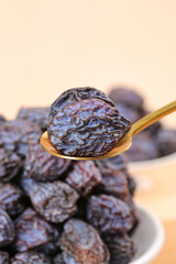 Dried Plum Fruit on Golden Spoon - Healthy Snack Display with Shallow Depth of Field